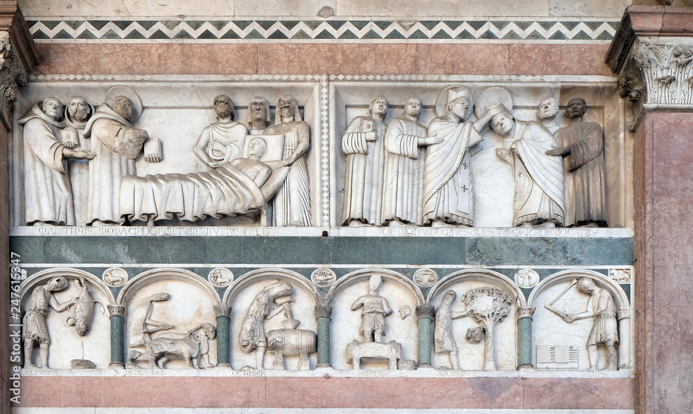 Fototapeta premium Detail of the bas-relief representing the Stories of St. Martin and the Labor of the months of the year; preserved in the Portico of the Cathedral of St. Martin in Lucca, Italy