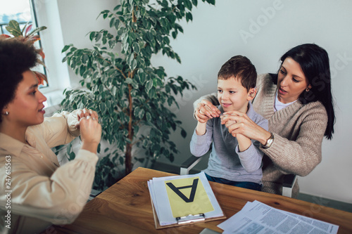 Smiling deaf boy learning sign language photo