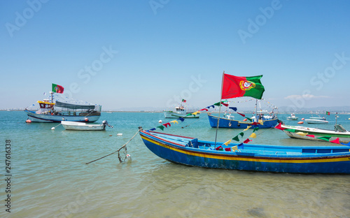 ALGARVE, PORTUGAL. AUGUST, 15 - 2018: Fishing boats decorated with pennants to celebrate the festivities of the Virgin of the Sea. Beach of Farol Island in Formosa Estuary.