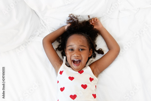 Happy girl lying on back holding arms above head