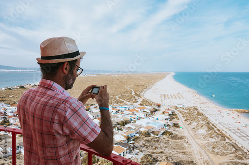 Man taking a photo from the top of the lighthouse  of Farol Island in Formosa Estuary, Algarve, Portugal.