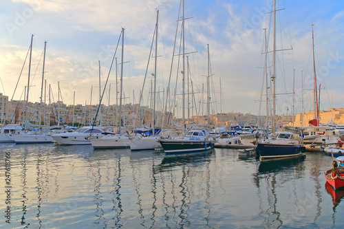 Sunset over moored yachts in a quiet bay in Malta. © scena15