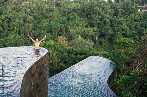 Man stands at the edge of an infinity pool