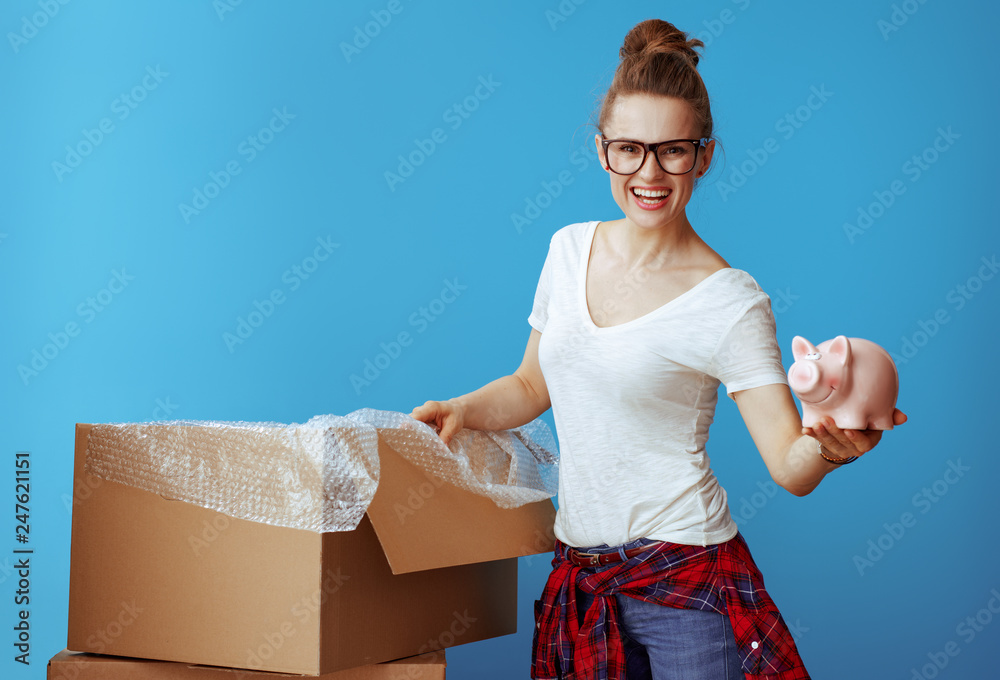 smiling young woman in white t-shirt on blue showing piggybank smiling young woman in white t-shirt on blue showing piggybank