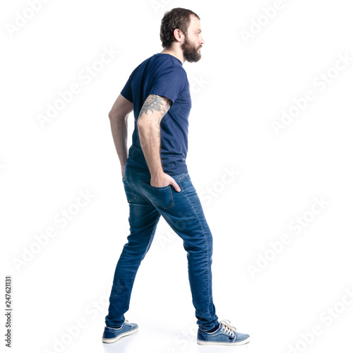 A man in jeans looks goes on a white background. Isolation, back view