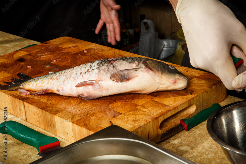 big fresh fish lie on kitchen cutting board