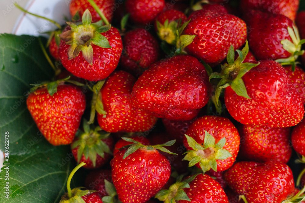 Red strawberries on a white plate. A lot of berries. Summer fruits Red strawberries on a white plate. A lot of berries. Summer fruits