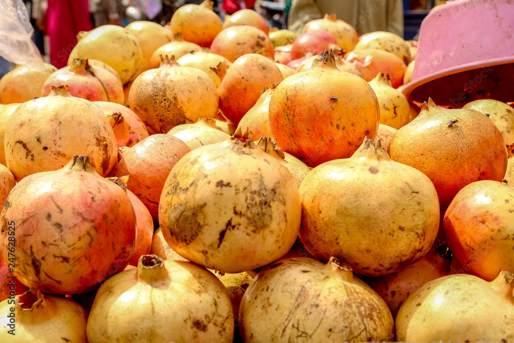 Lot of granada fruit in a market, for background usage. pomegranate fruit in the market in Essaouira, Morocco Lot of granada fruit in a market, for background usage. pomegranate fruit in the market in Essaouira, Morocco