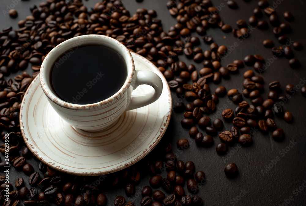 Coffee cup with roasted beans on stone background Coffee cup with roasted beans on stone background