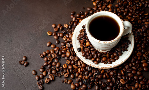 Coffee cup with roasted beans on stone background 