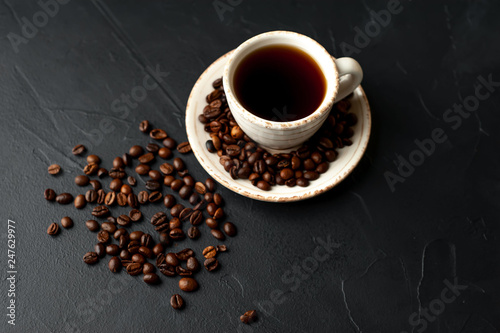 Coffee cup with roasted beans on stone background 