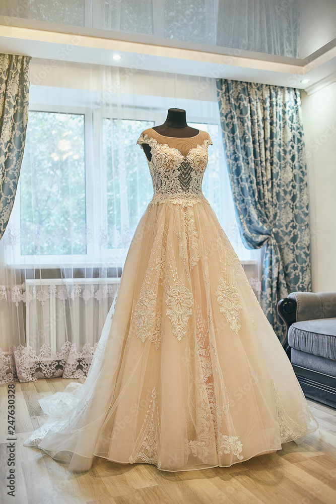 beautiful wedding dress hanging in the room, woman getting ready before ceremony beautiful wedding dress hanging in the room, woman getting ready before ceremony