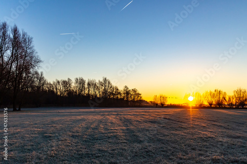The pasture next to lake Zoetermeerse plas is frosted when the sun rises and the sky gets wonderful colors