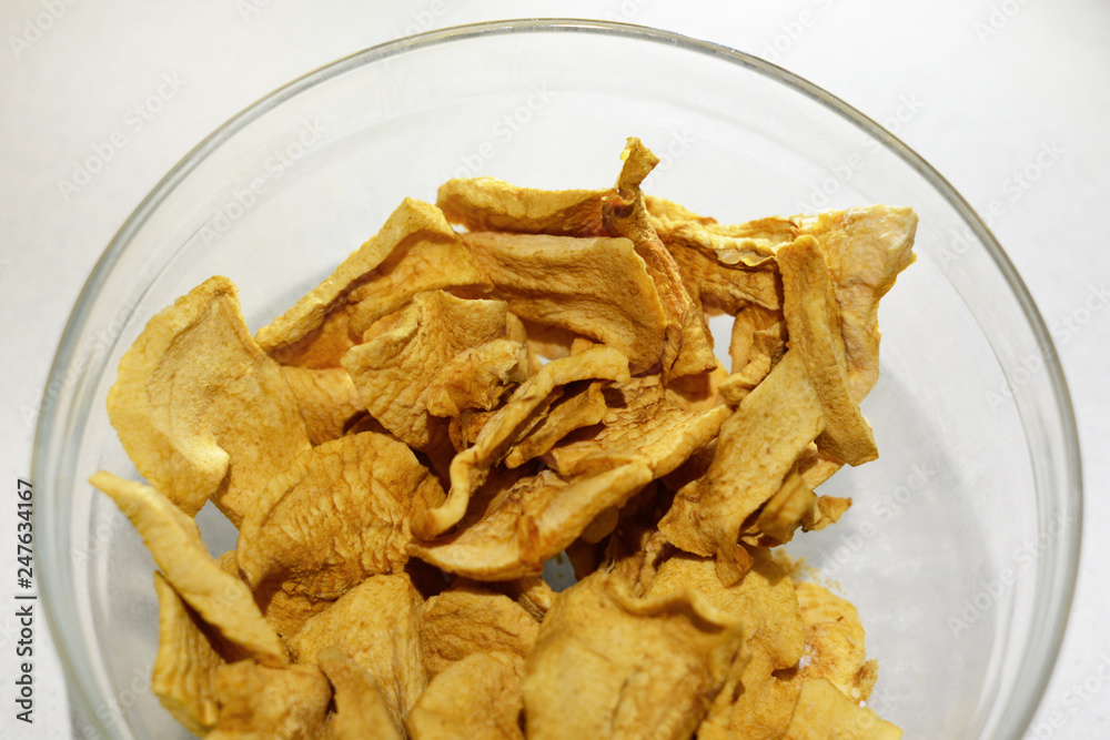 Sliced dried homemade apple chips in a bowl