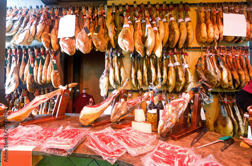 Legs of traditional  Spanish jamon fixed on wooden jamoneras ready for sale
