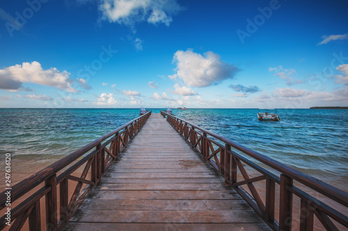 Wooden pier on a tropical island, clear sea and blue sky. Punta Cana, Dominican Republic