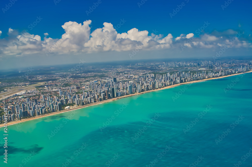 Aerial city view with many buildings, blue sky and sea