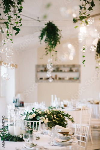 Wedding dinner table set. Classy white decor with greenery © IVASHstudio