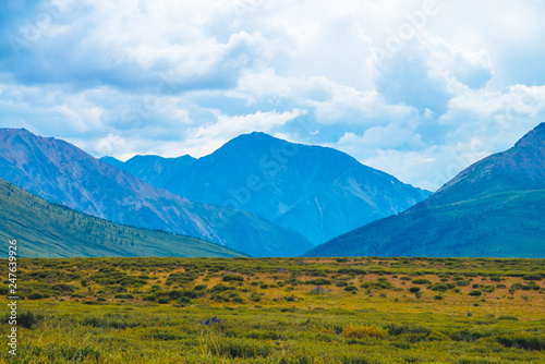 Spectacular view of giant mountains under cloudy sky. Huge mountain range at overcast weather. Wonderful wild scenery. Atmospheric dramatic highland landscape of majestic nature. Scenic mountainscape.