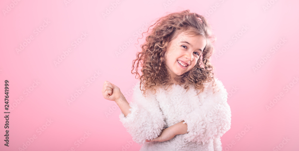 Portrait of girl pointing finger at up on pink Portrait of girl pointing finger at up on pink