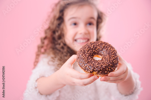 Portrait of a little smiling girl with donuts