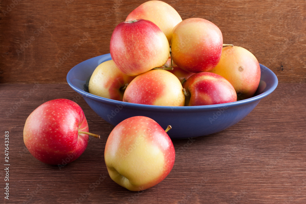 apples in a blue clay bowl on a wooden table apples in a blue clay bowl on a wooden table