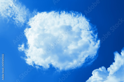 Fluffy round cloud in clear blue sky. Peaceful cloudy sky natural background, frame. Sunny day, light. Divine shining heavenly background, heaven