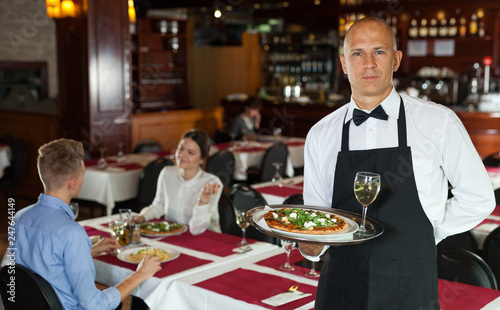 Waiter with serving tray meeting guests