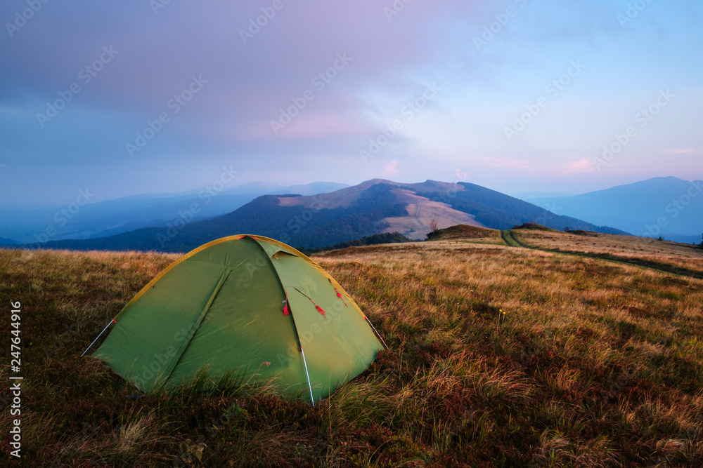 Green tent in spring mountains. Amazing evening highland. Landscape photography
