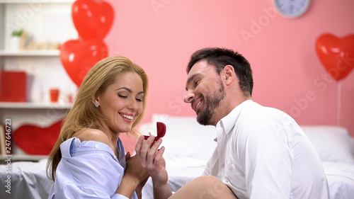 Happy man presenting his girlfriend engagement ring on Valentines day, holiday