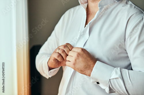 businessman dresses white shirt, male hands closeup,groom getting ready in the morning before wedding ceremony. Men Fashion