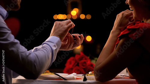 Man proposing beloved lady at romantic dinner in restaurant on st Valentines day photo