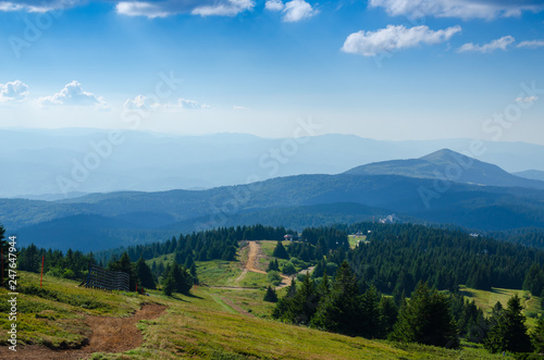 Mountain road through green meadows and hills of mountain Kopaonik, Serbia, in summer photo