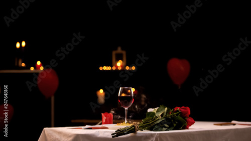 Εκτύπωση καμβά Red roses on table near glass of wine, romantic atmosphere, st Valentines Day