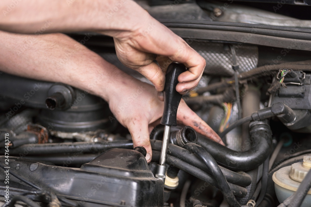 Auto mechanic working on car engine at repair service. Close up view . Auto mechanic working on car engine at repair service. Close up view .