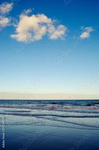 Blue sky meeting the blue ocean waves on beach, cape tribulation 