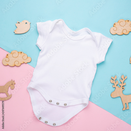 mockup Flat Lay a white children's shirt with wooden toys on a colored background. Layout for the design and placement of logos, advertising, children's party baby shower, children's birthday