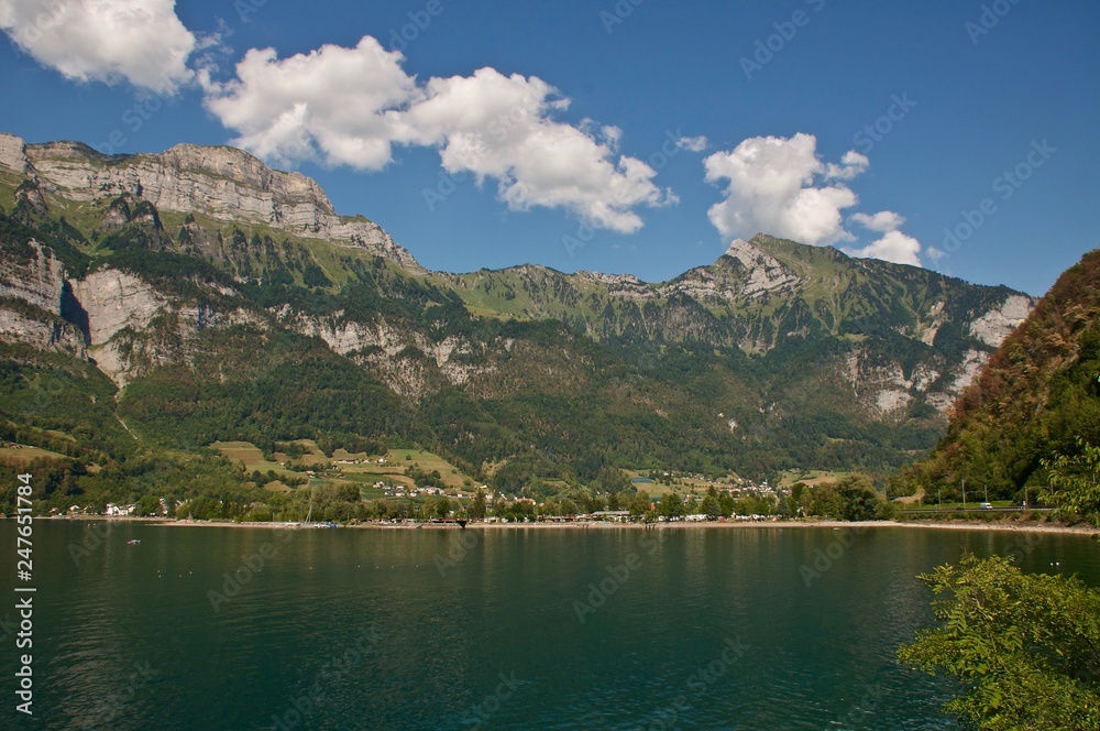 Walensee ( Schweizer See ) im Hintergrund die Berge Churfirsten: Frümsel, Hinterrugg, Brisi,. im Hintergrund der Campingplatz von Walenstadt.