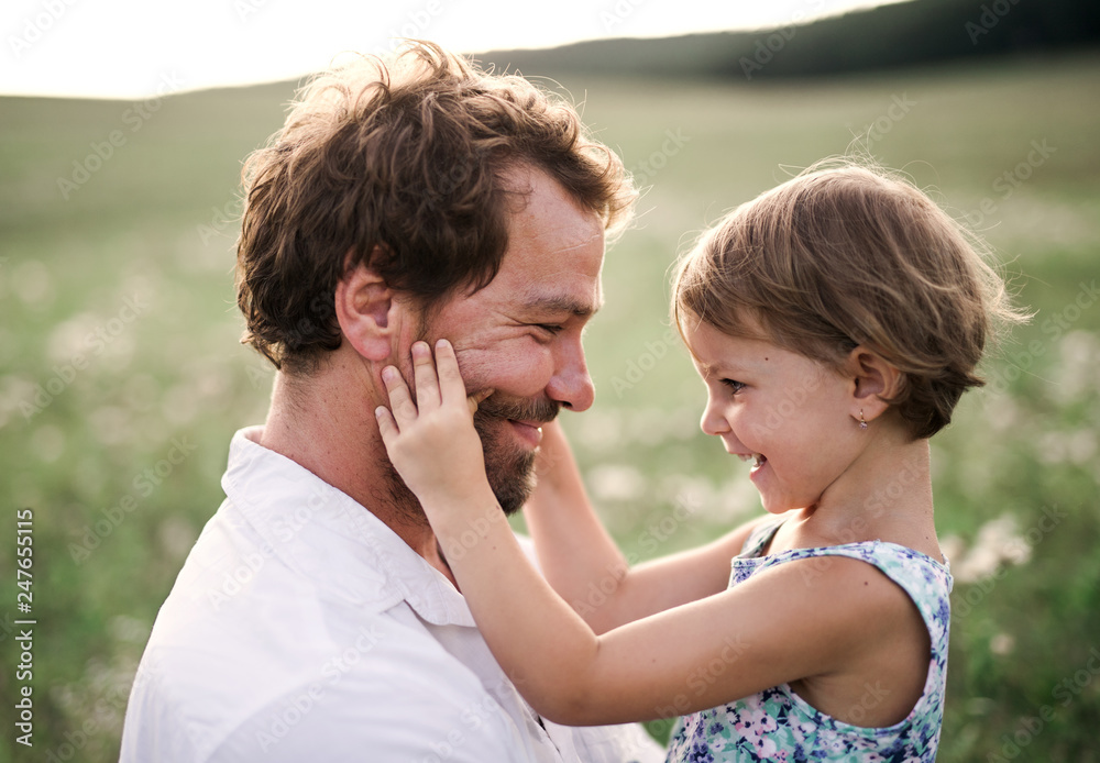Young father in nature holding small daughter in the arms. Young father in nature holding small daughter in the arms.