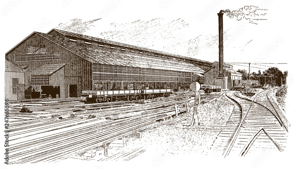 Fototapeta premium Exterior view of antique factory building with rails, wagons and smoking chimney