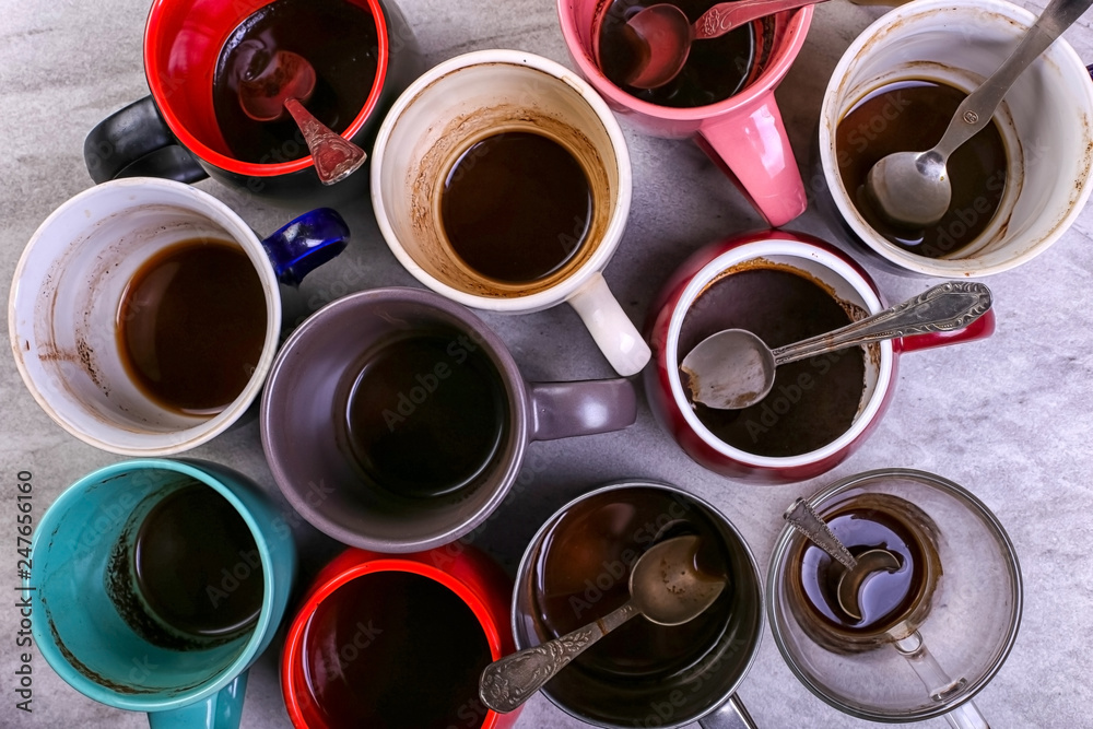 Empty dirty coffee cups of different colors on the table. Concept of caffeine dope, lack of energy and long wait. Copy space. Empty dirty coffee cups of different colors on the table. Concept of caffeine dope, lack of energy and long wait. Copy space.