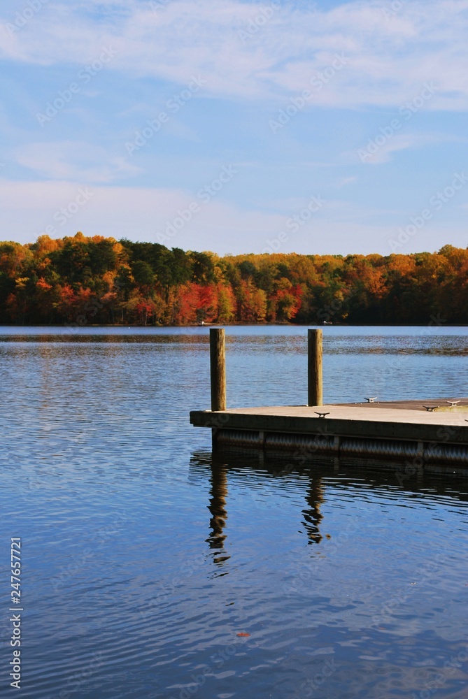 Lakeside View of Lake, Wood Pier, Fall or Autumn Foliage lining the edge of Burke Lake Virginia 