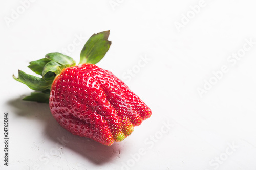 Ugly organic home grown strawberries isolated on white photo