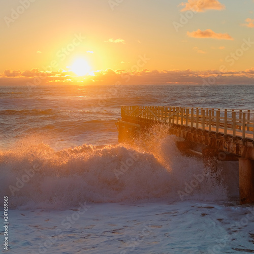 Yellow sun lights big storm waves. Sunset on the sea. Beautiful nature. photo