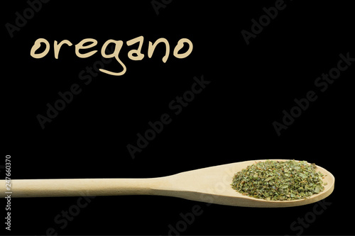 oregano on wooden spoon isolated on black background