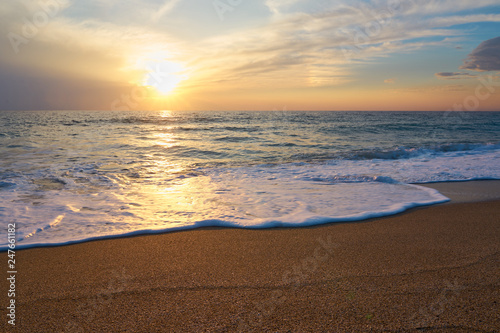  Tropical sandy beach. Sunset seascape. Waves with foam hitting sand.