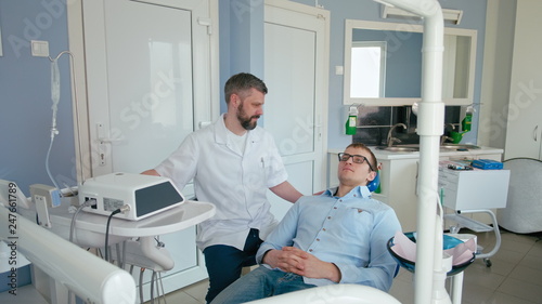 Young Man is Visiting Dentist Doctor in the Dental Office in the Medic Clinic. Health and Dental Care: Man at work as Dentist and Doctor, Meeting Patient in Professional Laboratory
