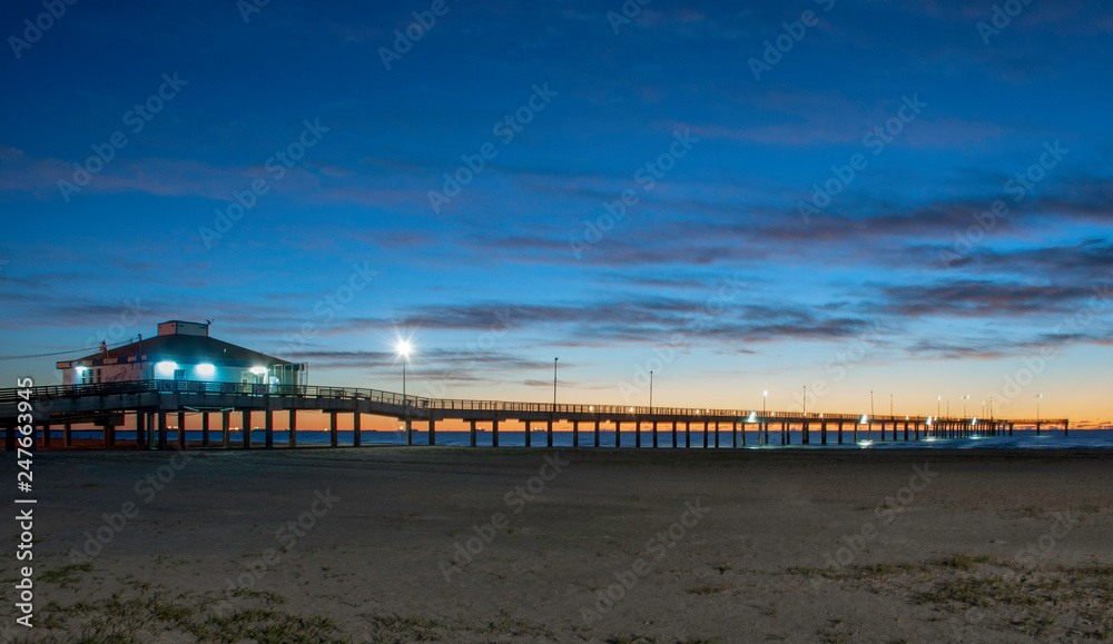 Sun rising behind pier in Port Aransas TX