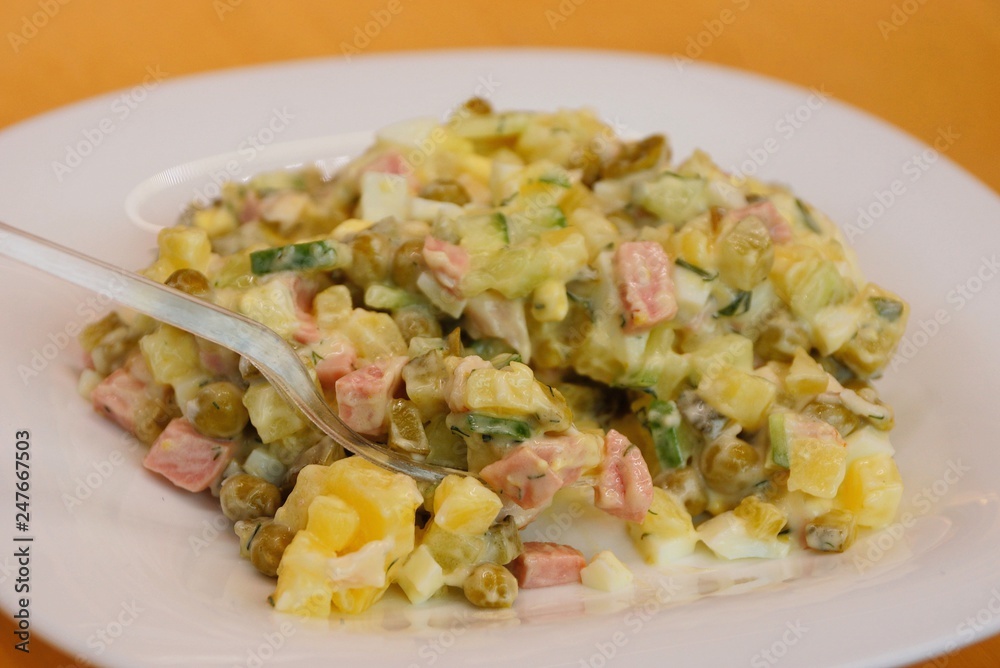 salad with mayonnaise on a white plate with a spoon salad with mayonnaise on a white plate with a spoon