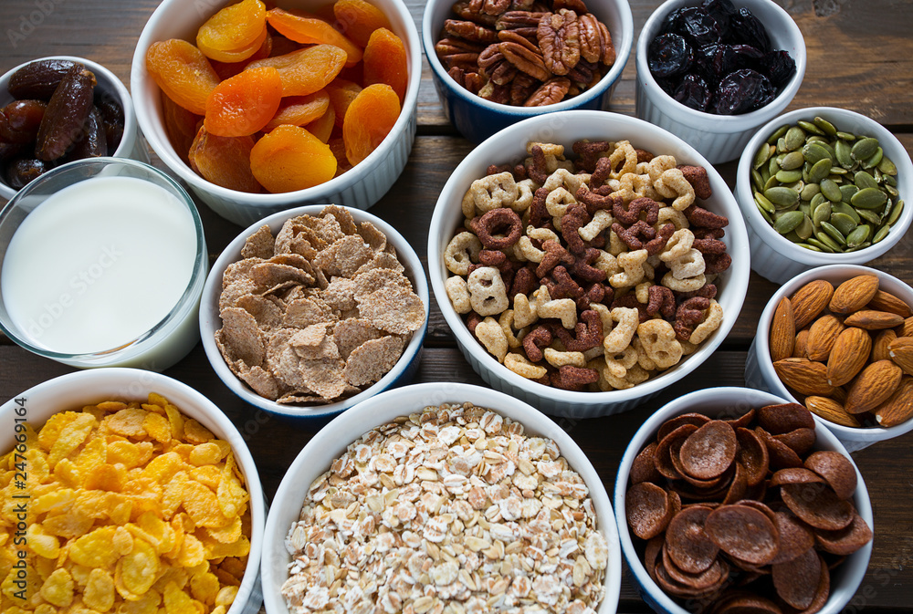 various cereals, nuts and dried fruits on wooden surface various cereals, nuts and dried fruits on wooden surface